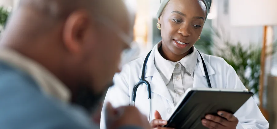 Médecin présentant un suivi de santé à un collaborateur sur tablette